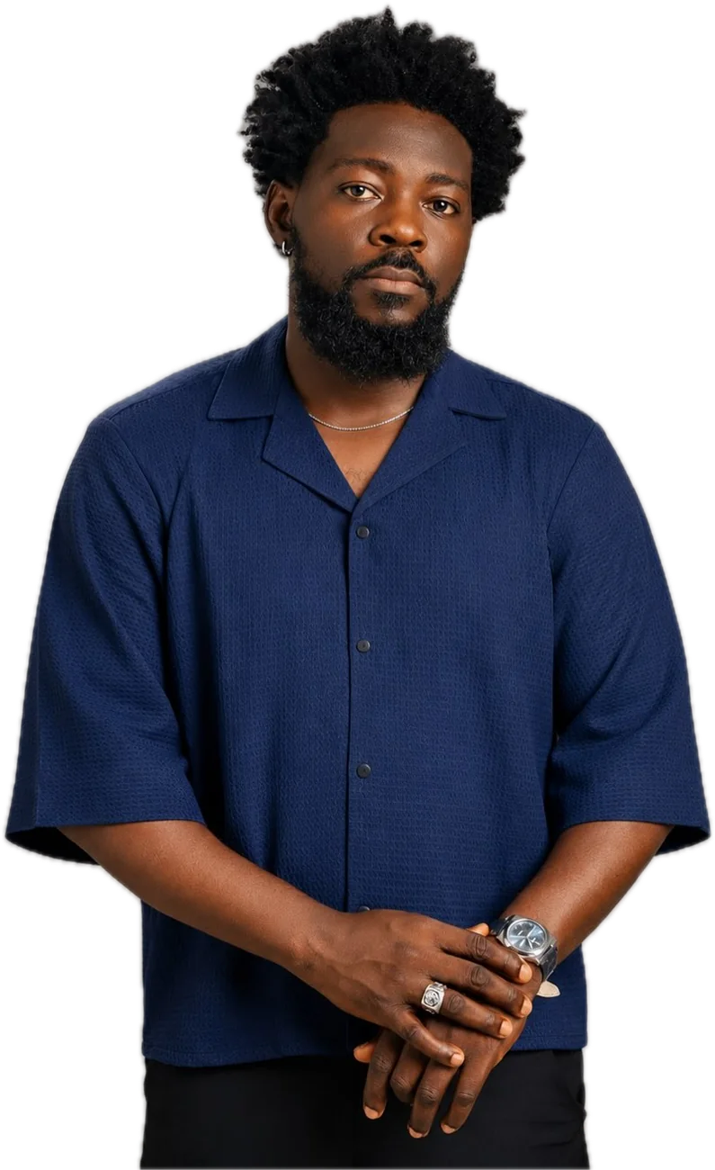 The cropped shirt in navy, worn with hands clasped